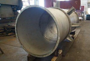 custom metal fabricated piping for ships in a warehouse