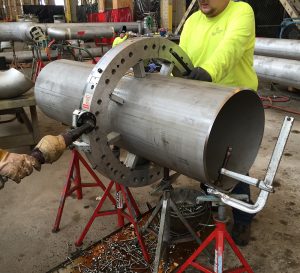 custom metal fabricated component being worked on by machinists