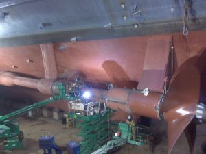 government ship repair by worker on scaffold with welding torch